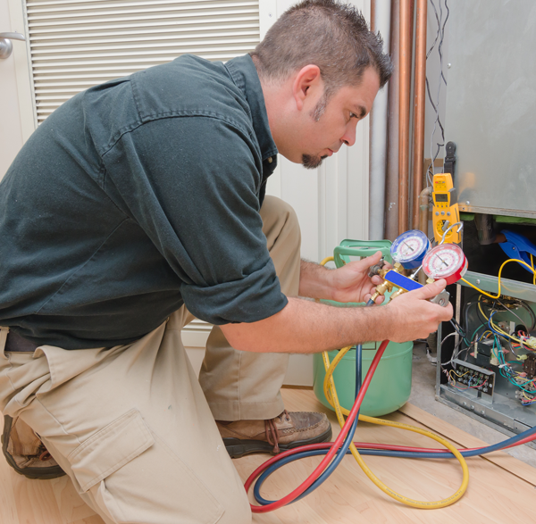 Photo of an HVAC technician checking gauges